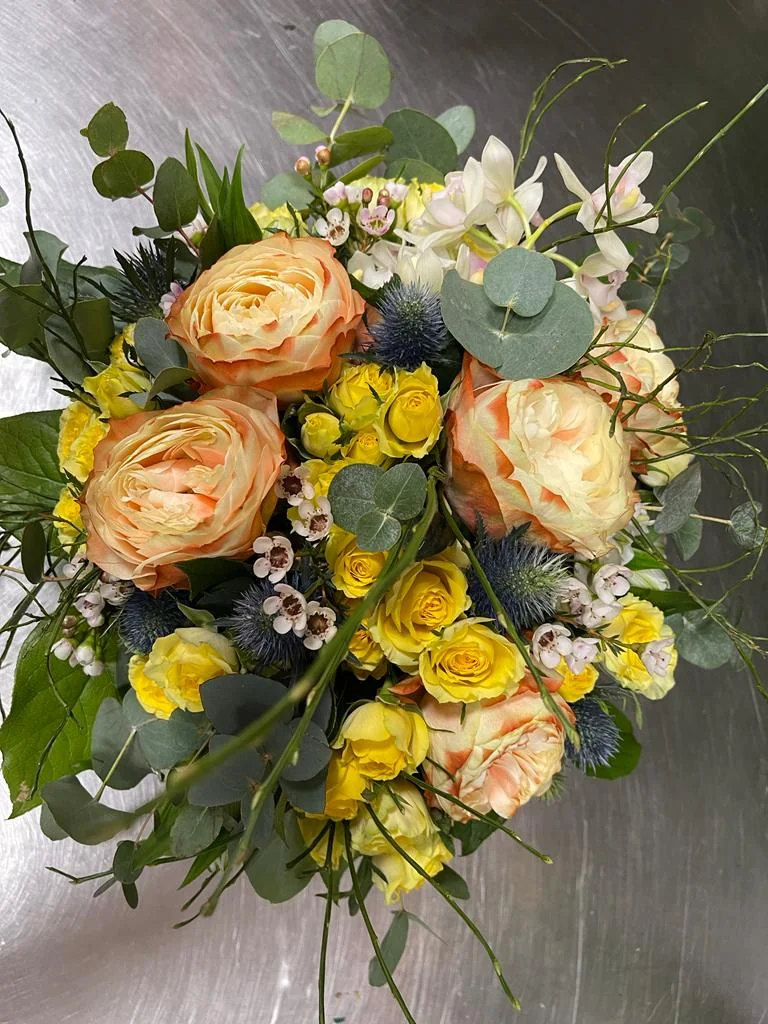 Mazzo di rose pesca e gialle con eucalipto
